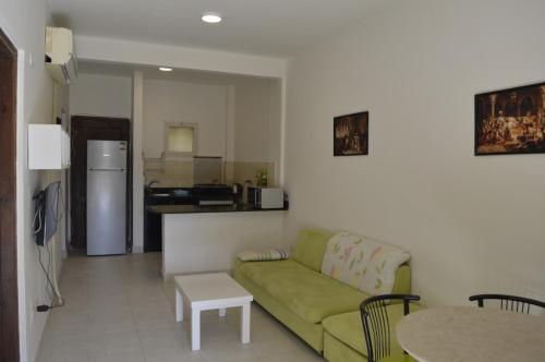 a living room with a green couch and a kitchen at f- ground floor with garden in Hurghada