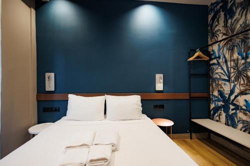 a bed in a room with a blue wall at K2 Suites Kalamata in Kalamata