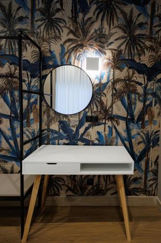 a dressing table with a mirror and a wall with palm trees at K2 Suites Kalamata in Kalamata