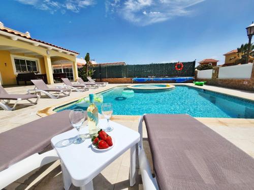 a table with a plate of fruit on it next to a swimming pool at Villa Amarillo in Caleta De Fuste
