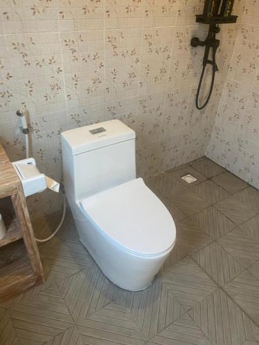 a bathroom with a white toilet in a room at D'A HOUSE in Amed