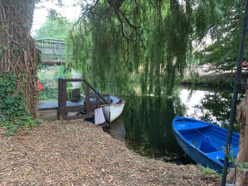 a boat is docked next to a dock on a river at Broadwalk7 in Coltishall
