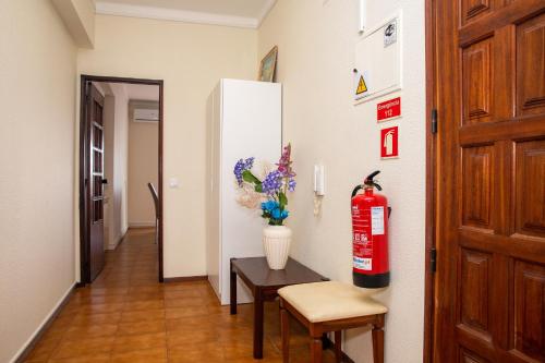 a room with a fire extinguisher and a table and a door at Macrisbete 2 in Fátima