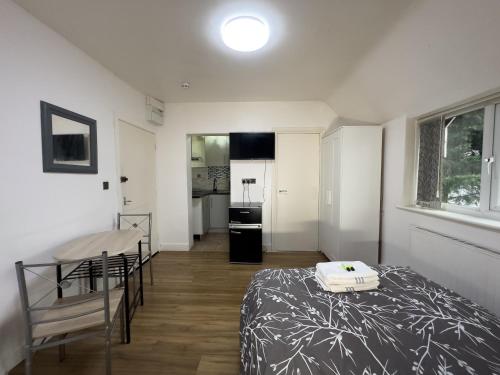a bedroom with a bed and a table and a kitchen at Hills View Apartments in Manchester