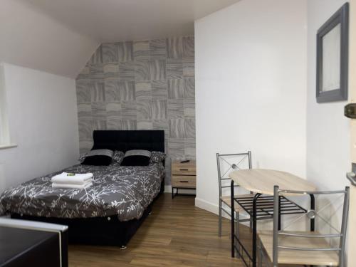 a bedroom with a bed and a table and a chair at Hills View Apartments in Manchester