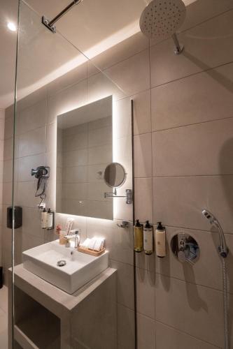 a bathroom with a sink and a shower at IRA - ΗΡΑ Hotel in Kalamata