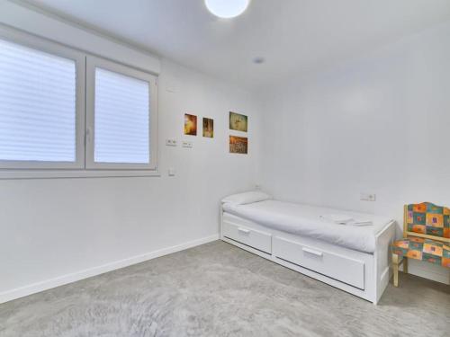 a white bedroom with a bed and a window at Apartment Sua Loft by Clabao in Pamplona