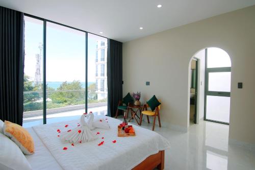 Un dormitorio con una cama blanca con flores rojas. en Villa View Biển Bãi Dâu - Đi Bộ Ra Biển 200 Met, en Vung Tau
