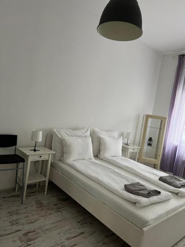 um quarto com uma grande cama branca e um candeeiro em kiko's forest em Budapeste