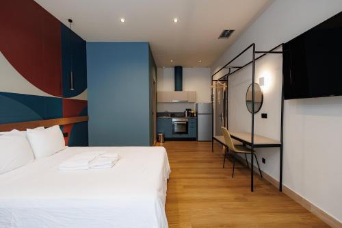 a bedroom with a bed and a desk and a kitchen at K2 Suites Kalamata in Kalamata
