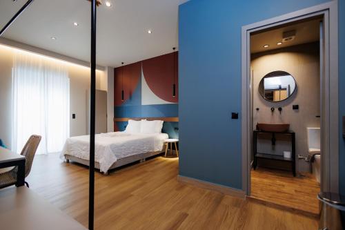 a bedroom with a bed and a mirror at K2 Suites Kalamata in Kalamata