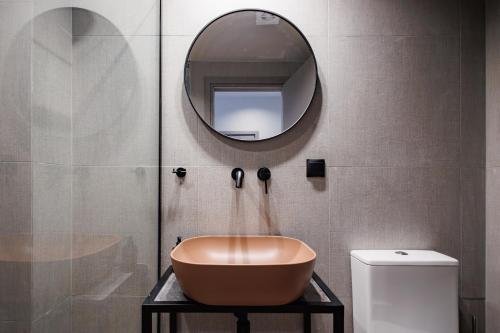 a bathroom with a bowl sink and a mirror at K2 Suites Kalamata in Kalamata