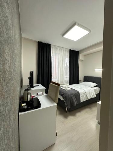 Schlafzimmer mit einem Bett und einem Schreibtisch mit einem Computer in der Unterkunft Özdemir Inn Otel in Balıkesir