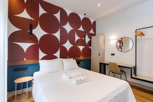 a bedroom with a white bed with a red wall at K2 Suites Kalamata in Kalamata