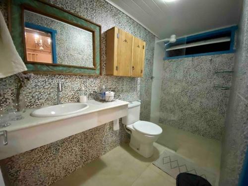 a bathroom with a sink and a toilet at Cantinho Almeida in Tiradentes