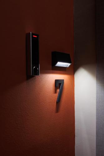 a number on a wall with a light at K2 Suites Kalamata in Kalamata