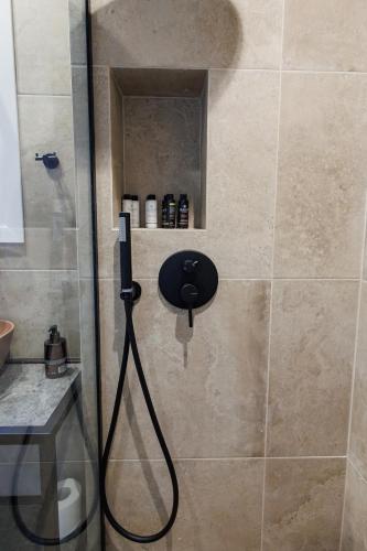 a shower with a black hose in a bathroom at K2 Suites Kalamata in Kalamata