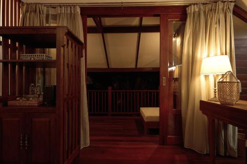 Jambolan Chiangmai في شيانغ ماي: غرفة معيشة مع باب يفتح على شرفة