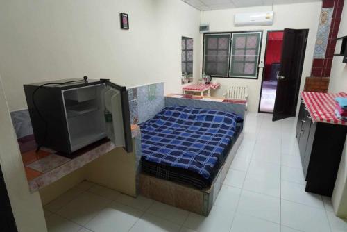Cette chambre comprend un lit et une télévision. dans l'établissement RTW Residence 415, à Bang O