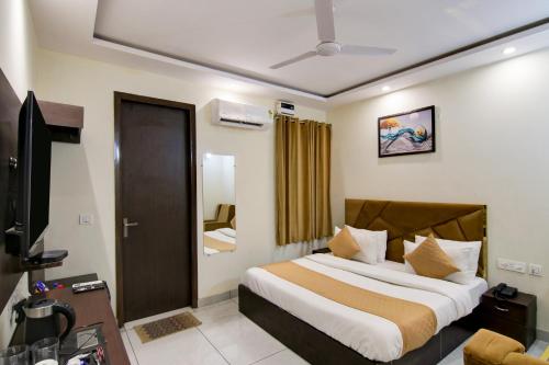 sypialnia z łóżkiem i telewizorem w obiekcie Hotel De Hocks Deluxe - New Delhi w Nowym Delhi