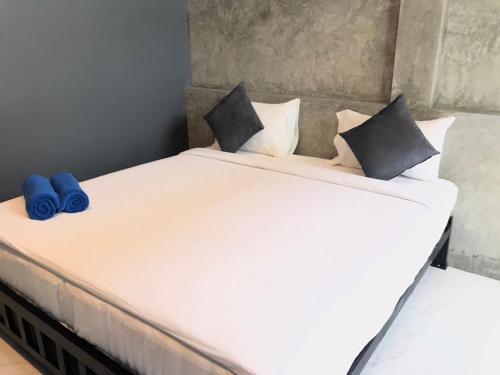 a large white bed with blue pillows on it at NemoCottage in Ban Khlong Haeng