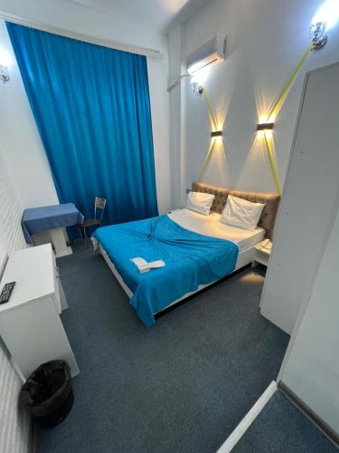 um pequeno quarto com uma cama com uma cortina azul em Best Center Boutique Hotel em Baku