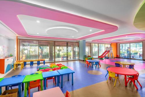 a classroom with tables and chairs and a play area at SUN HEAVEN FAMILY & SPA in Alanya