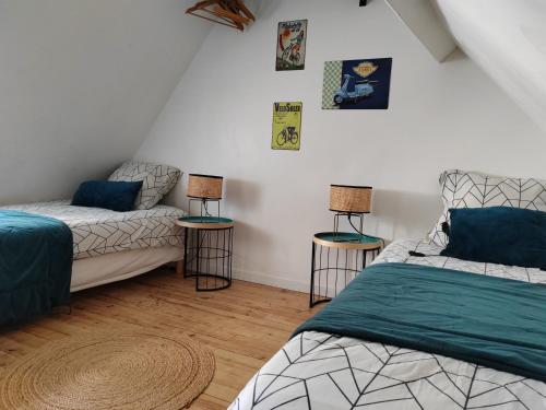1 dormitorio con 2 camas y 2 lámparas en las mesas en LA PETITE BEAUVAISIENNE en Beauvais