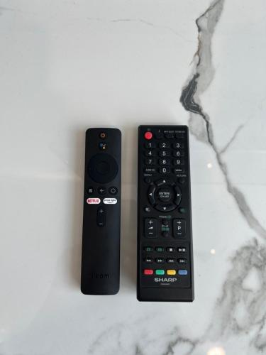 two remote controls sitting next to each other on a counter at Rayyan Condominium @ Metrocity Square in Kuching