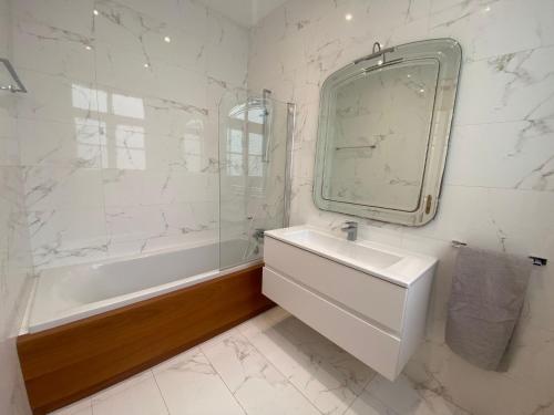 La salle de bains est pourvue d'une baignoire, d'un lavabo et d'un miroir. dans l'établissement SeaView Valletta Apartment, à La Valette