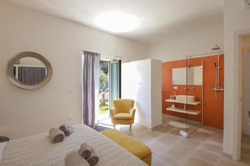 een slaapkamer met een bed en een badkamer met een wastafel bij Trulli Dimore - Villa Coco in Ostuni