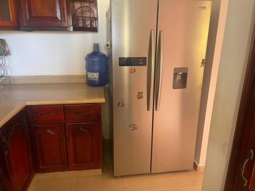 a kitchen with a stainless steel refrigerator with a bottle of water at room in 2bedroom apartment, white Sands, Bavaro in Punta Cana