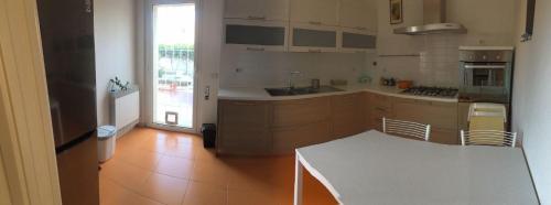a kitchen with a counter and a table in it at Romantische Villa am Meer mit Kamin Zoomarine Cinecittà World in Torvaianica
