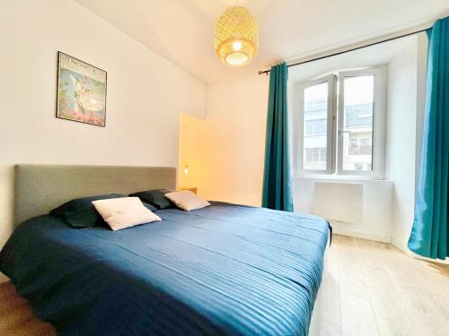sypialnia z niebieskim łóżkiem i oknem w obiekcie Nantes - Le Bellamy - Authentique - Proche Centre Ville w mieście Nantes