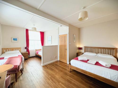 a bedroom with two beds and a table and chairs at The Western in St Ives