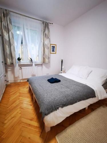 een slaapkamer met een groot bed en een raam bij Cosy condo in Warschau