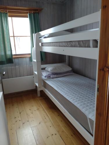 een stapelbed in een kamer met een houten vloer bij Fyrklöverns Stugby in Rättvik