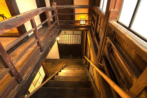 a stairway in a building with wooden stairs and windows at GLOCE西会津 ふくの屋 l 古きを知り新しきを愉しむ l 築110年超の古民家が綴る心地よい宿 in Yanaizu