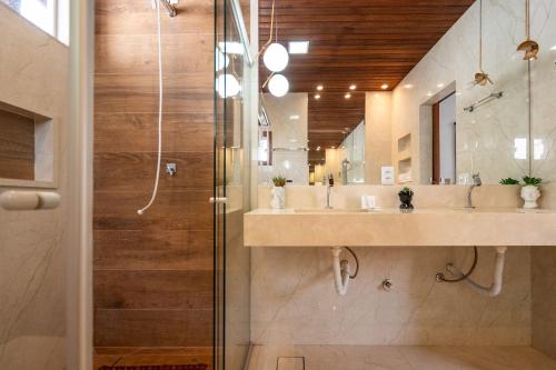 uma casa de banho com 2 lavatórios e um chuveiro em Chácara Luxuosa em Goiânia UPR0011 em Goiânia