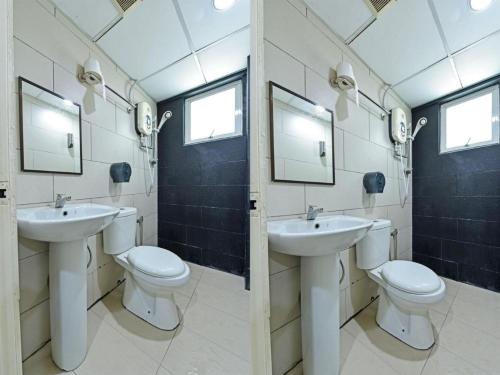 uma casa de banho com 2 lavatórios e 2 WC em One Enigma Hotel em Kuala Lumpur