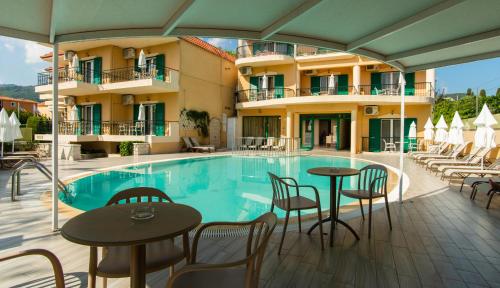 un hotel con piscina, mesas y sillas en Konstantinos Hotel & Apartments 2, en Nydri