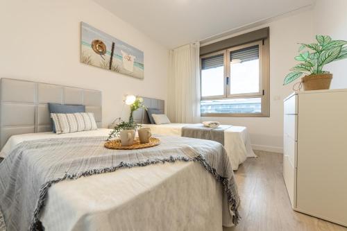 ラ・ピネーダにあるHomes & Go Los Olivosのベッド2台と窓のある寝室