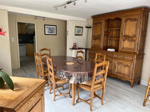 une salle à manger avec une table et des chaises en bois dans l'établissement Le Puits du Village, à Mont-Saint-Aignan