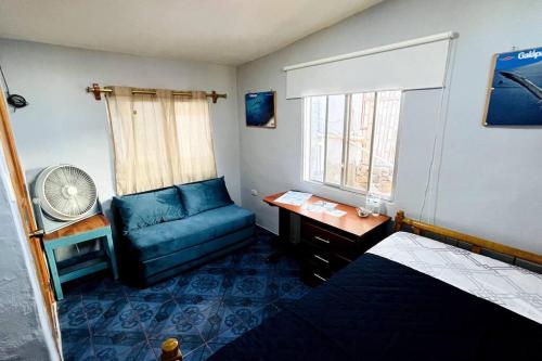 Habitación pequeña con sofá azul y ventana en Cómoda habitación privada 2 personas FULL BED & FULL SOFA CAMA en Puerto Ayora