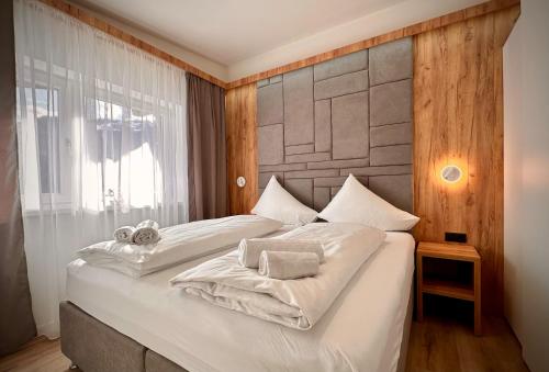 een slaapkamer met een groot wit bed en handdoeken bij mountain view in Piesendorf