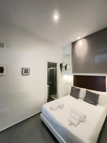 a bedroom with a large white bed with towels on it at Hotel Assisivm Antica Dimora AD in Assisi