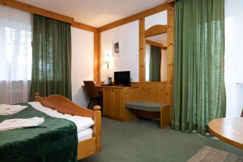 a hotel room with a bed and a desk at Hotel zum See, Titisee in Titisee-Neustadt