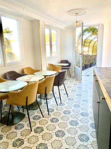 d'une salle à manger avec des tables et des chaises sur du carrelage. dans l'établissement Villa Caprice, à Six-Fours-les-Plages
