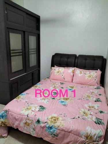 a bedroom with a pink bed with a black headboard at HOMESTAY OMAK AYAH in Seremban