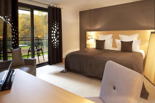 En eller flere senge i et værelse på L'Aubinière Hôtel Restaurant & Spa